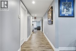 Hallway with wood-finish flooring, recessed lighting, and light gray painted walls - 