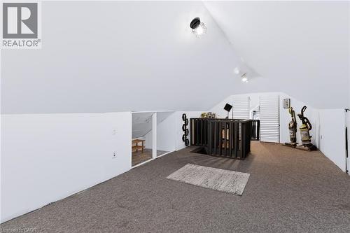 Carpeted loft space with sloped ceilings, recessed lighting, and a dark wood-finish railing - 703 Brighton Avenue, Hamilton, ON - Indoor Photo Showing Other Room