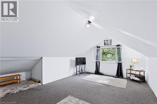 Bright attic space with white painted walls, gray carpeting, and an operable window - 703 Brighton Avenue, Hamilton, ON - Indoor Photo Showing Other Room