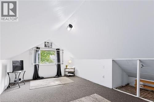 Sloped ceilings with recessed lighting, carpet flooring, and a large casement window - 703 Brighton Avenue, Hamilton, ON - Indoor