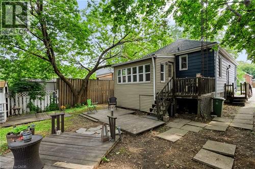 Expansive backyard featuring a mature tree, wood fencing, and a combination of wood decking and concrete pavers - 703 Brighton Avenue, Hamilton, ON - Outdoor With Deck Patio Veranda