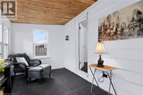 Wood-finish plank ceiling, white horizontal plank wall paneling, and dark patterned carpet flooring - 703 Brighton Avenue, Hamilton, ON - Indoor