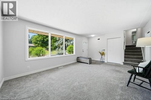 Expansive window wall, grey carpet flooring, white walls, white trim, and a built-in closet with bi-fold doors - 64 Warren Road, Kitchener, ON - Indoor Photo Showing Other Room