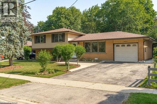 Split-level residence featuring brick and siding exterior, attached garage, paved driveway, and established front landscaping - 64 Warren Road, Kitchener, ON - Outdoor