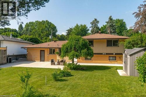 Expansive lawn area with a concrete patio and a detached storage shed - 64 Warren Road, Kitchener, ON - Outdoor