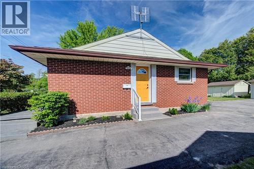 Brick exterior with light-colored siding, a brightly colored front door, and a paved driveway - 251 Union Street E, Waterloo, ON - Outdoor