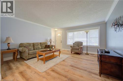 Light wood-finish flooring, white trim, and a large window with blinds - 251 Union Street E, Waterloo, ON - Indoor Photo Showing Living Room