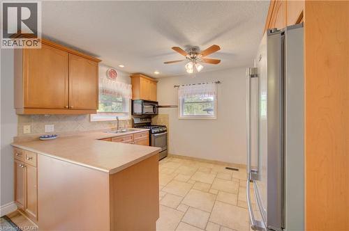 Kitchen featuring wood-finish cabinetry, tile flooring, recessed lighting, and a ceiling fan - 251 Union Street E, Waterloo, ON - Indoor Photo Showing Kitchen With Double Sink