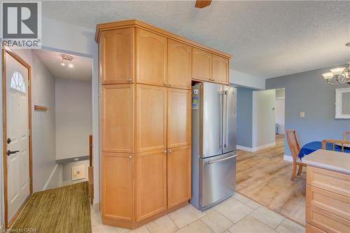 Integrated stainless steel refrigerator, extensive wood-finish cabinetry, recessed ceiling light fixture, wood-finish flooring, and tile flooring - 251 Union Street E, Waterloo, ON - Indoor