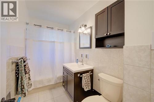 Dark wood-finish vanity with an integrated sink, polished chrome faucet, and mirrored medicine cabinet - 251 Union Street E, Waterloo, ON - Indoor Photo Showing Bathroom