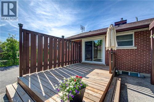 Expansive wood deck with privacy fencing, red brick exterior, and a sliding glass door entry - 251 Union Street E, Waterloo, ON - Outdoor
