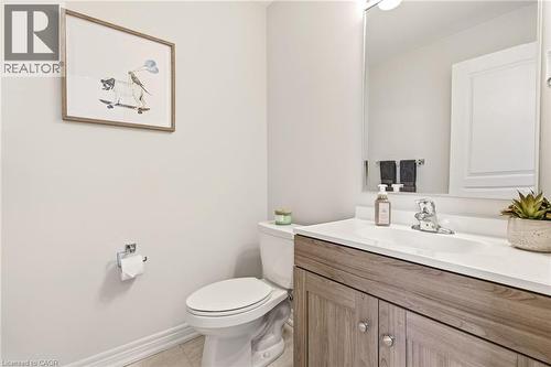 Spa-inspired bathroom featuring a wood-finish vanity with dual-sink configuration, white quartz countertop, and chrome fixtures - 4171 Palermo Common, Burlington, ON - Indoor Photo Showing Bathroom