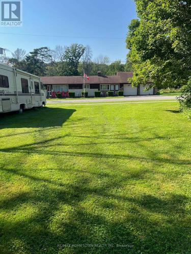 Vacant lot next to the garage with mature trees - 116 Mill Creek Drive, Rideau Lakes, ON 