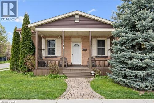 Brick facade with brown siding, covered front porch with wood columns and railing, front yard with mature landscaping, and a paver stone walkway - 27 Roseview Avenue, Cambridge, ON - Outdoor With Deck Patio Veranda
