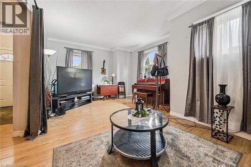 Light wood-finish flooring, crown molding, and multiple windows with drapery - 27 Roseview Avenue, Cambridge, ON - Indoor Photo Showing Living Room