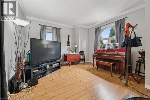 Wood-finish flooring throughout, crown molding, and an arched window - 27 Roseview Avenue, Cambridge, ON - Indoor Photo Showing Living Room