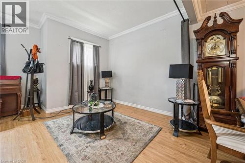 Light-toned wood-finish flooring, white crown molding, and a window with neutral-toned drapes - 27 Roseview Avenue, Cambridge, ON - Indoor
