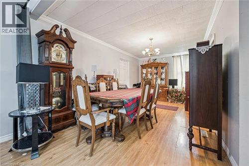 Wood-finish flooring, crown molding, and a chandelier illuminate the space - 27 Roseview Avenue, Cambridge, ON - Indoor Photo Showing Dining Room