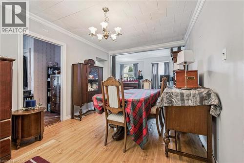 Wood-finish flooring with crown molding and a ceiling-mounted light fixture - 27 Roseview Avenue, Cambridge, ON - Indoor Photo Showing Dining Room