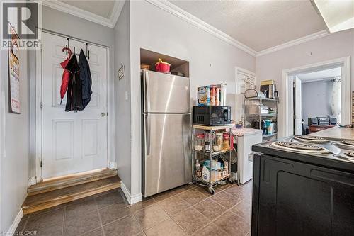 Stainless steel refrigerator, tile flooring, crown molding, and a built-in oven range - 27 Roseview Avenue, Cambridge, ON - Indoor Photo Showing Laundry Room
