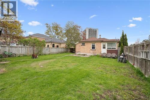 Expansive backyard featuring a mature, manicured lawn bordered by wooden privacy fencing - 27 Roseview Avenue, Cambridge, ON - Outdoor With Backyard