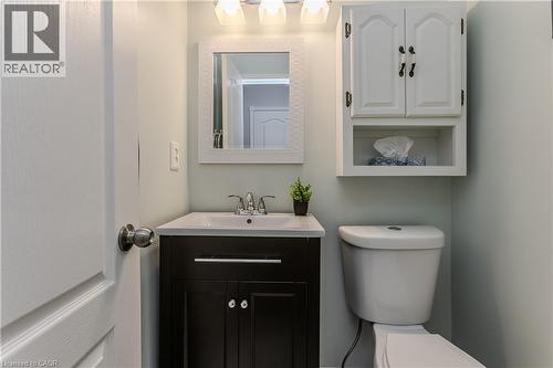 Dark wood vanity with a white integrated sink and chrome faucet - 1238 Sable Drive, Burlington, ON - Indoor Photo Showing Bathroom