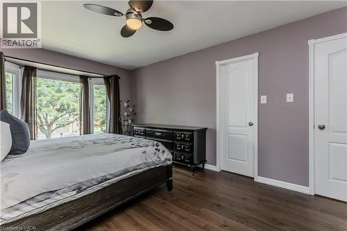 Bay window with a treetop outlook, wood-finish flooring, ceiling fan with integrated lighting, and two panel doors - 1238 Sable Drive, Burlington, ON - Indoor Photo Showing Bedroom