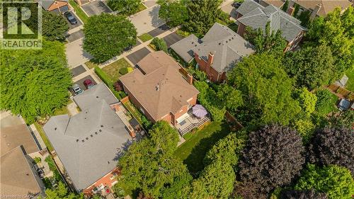 Residential property with a brick exterior, shingle roof, and a private backyard featuring a patio and surrounding greenery - 1238 Sable Drive, Burlington, ON - Outdoor With View