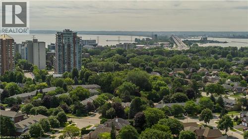 Aerial perspective of an urban landscape featuring diverse residential architecture, abundant mature trees, and a prominent body of water with a bridge structure - 1238 Sable Drive, Burlington, ON - Outdoor With Body Of Water With View