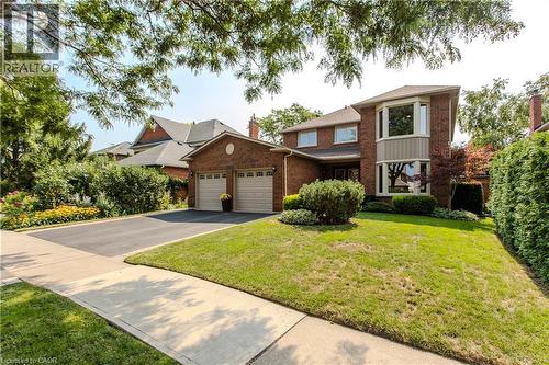 Brick-clad exterior with a two-car garage and a paved driveway - 1238 Sable Drive, Burlington, ON - Outdoor With Facade