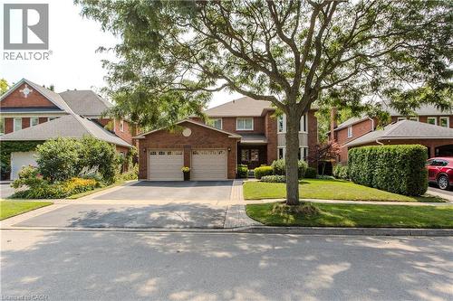 Brick facade residence with a two-car garage, asphalt driveway, and a stone paver walkway - 1238 Sable Drive, Burlington, ON - Outdoor With Facade