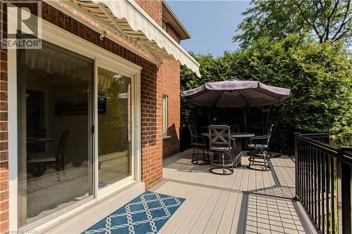 Composite decking with black metal railings, a retractable awning, and a brick exterior - 1238 Sable Drive, Burlington, ON - Outdoor With Deck Patio Veranda With Exterior