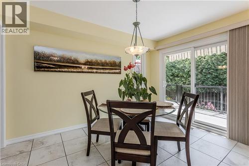 Bright dining area with pale yellow walls, tile flooring, and a pendant light fixture - 1238 Sable Drive, Burlington, ON - Indoor Photo Showing Dining Room