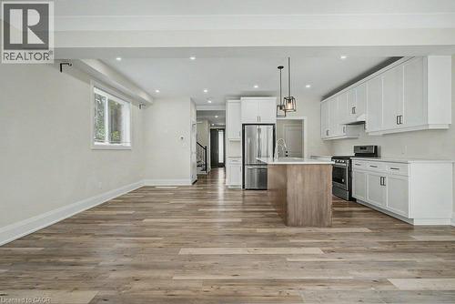 Open concept living area with wood-finish flooring, recessed lighting, and white cabinetry - 31 Fourth Avenue, Kitchener, ON - Indoor Photo Showing Kitchen With Upgraded Kitchen