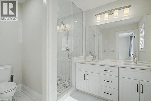 Double vanity with integrated sinks, white cabinetry, and matte black hardware - 31 Fourth Avenue, Kitchener, ON - Indoor Photo Showing Bathroom