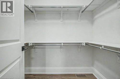 Walk-in closet with multiple white shelves and chrome hanging rods - 31 Fourth Avenue, Kitchener, ON - Indoor With Storage