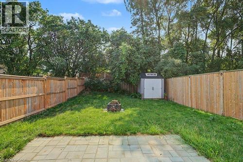 Expansive backyard featuring a paver patio, full privacy fencing, a manicured lawn, and a storage shed - 31 Fourth Avenue, Kitchener, ON - Outdoor With Backyard