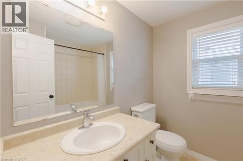 Vanity with integrated sink, wall-mounted mirror, overhead light fixture, toilet, and window with blinds - 248 Bridlewreath Street, Kitchener, ON - Indoor Photo Showing Bathroom