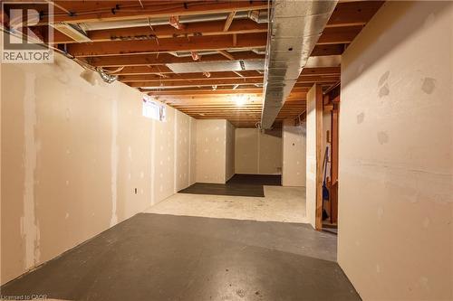 Unfinished basement with exposed ceiling joists, concrete flooring, and partial drywall - 248 Bridlewreath Street, Kitchener, ON - Indoor Photo Showing Basement