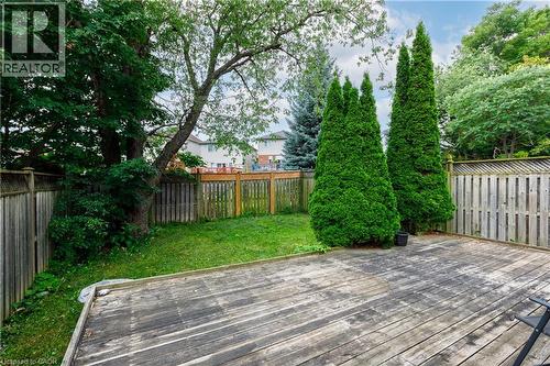 Expansive wood deck with a fenced perimeter, lush greenery, and mature trees - 248 Bridlewreath Street, Kitchener, ON - Outdoor
