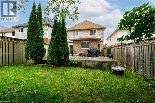 Expansive grassy yard featuring a multi-level wood deck and mature evergreen trees - 248 Bridlewreath Street, Kitchener, ON - Outdoor