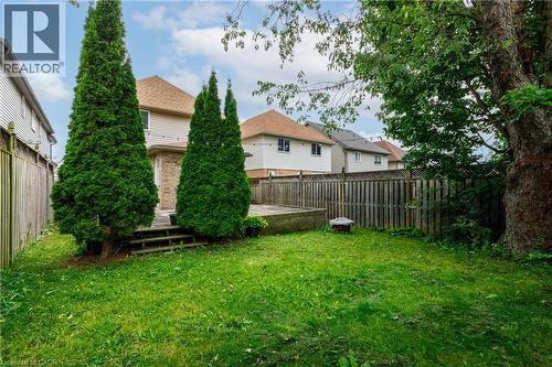 Expansive rear yard featuring a wooden privacy fence, mature trees, and a multi-level deck - 248 Bridlewreath Street, Kitchener, ON - Outdoor