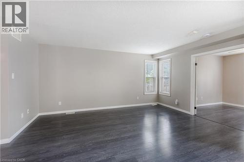 Dark wood-finish flooring with light wall paint and white trim - 248 Bridlewreath Street, Kitchener, ON - Indoor Photo Showing Other Room
