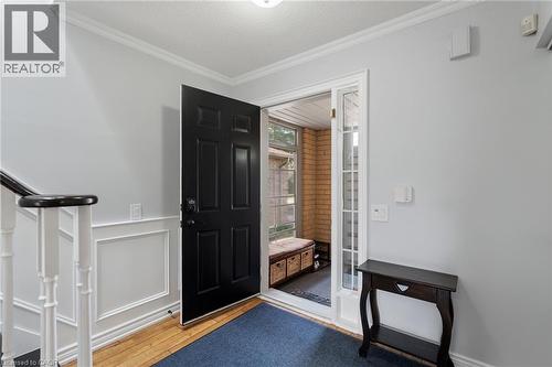 Entry foyer with wood-finish flooring, wainscoting, a paneled door, and a sidelight - 57 Grindstone Way, Waterdown, ON - Indoor Photo Showing Other Room