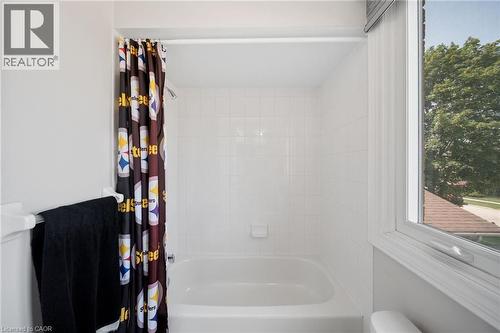White tiled shower surround with a built-in bathtub and a window - 57 Grindstone Way, Waterdown, ON - Indoor Photo Showing Bathroom