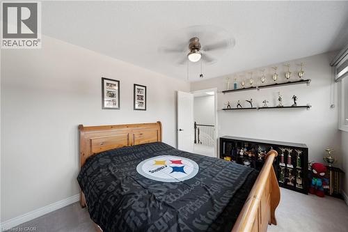 Ceiling fan with integrated lighting, built-in shelving, and a bright window - 57 Grindstone Way, Waterdown, ON - Indoor Photo Showing Bedroom