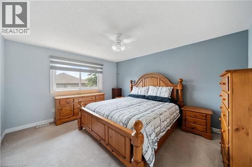 Soft gray wall paint with white trim, light neutral carpeting, and a window with horizontal blinds - 57 Grindstone Way, Waterdown, ON - Indoor Photo Showing Bedroom