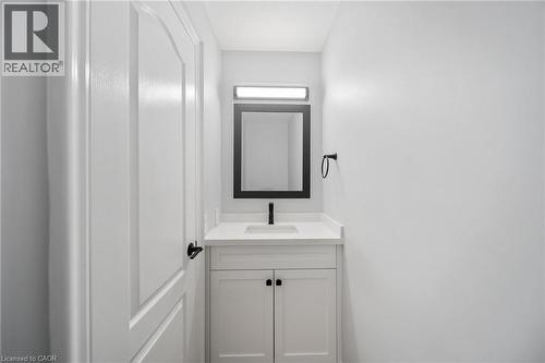White shaker-style vanity with a light-toned countertop and integrated sink - 57 Grindstone Way, Waterdown, ON - Indoor Photo Showing Bathroom