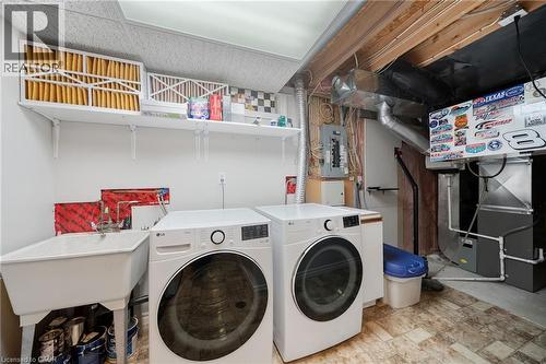 Functional utility area featuring a utility sink, wall-mounted shelving, and mechanical systems - 57 Grindstone Way, Waterdown, ON - Indoor Photo Showing Laundry Room