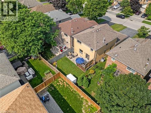 Expansive backyard featuring a manicured lawn, paved patio, and mature trees - 57 Grindstone Way, Waterdown, ON - Outdoor
